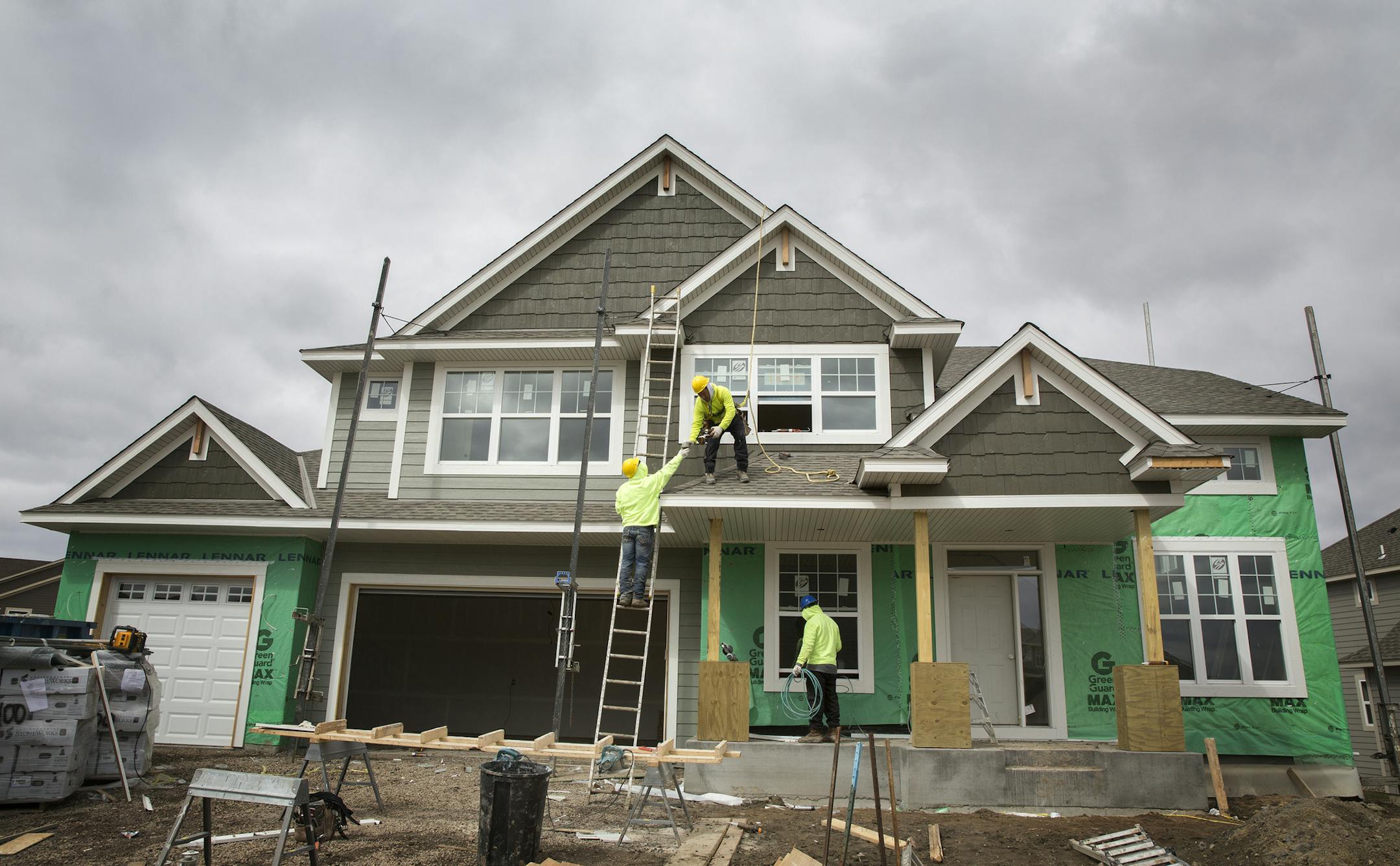 Construction workers build a home in the new Lennar Homes development called The Reserve at Spring Meadows in Plymouth.