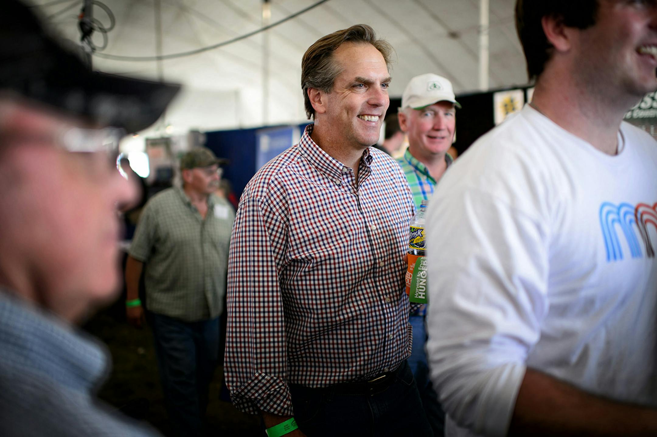 Mike McFadden circulated around Farmfest after the U.S. Senate Candidate's forum on agriculture and rural issues. Behind him is his cousin Vince McFadden who good naturedly ribbed him about who the best looking McFadden was. ] Wednesday, August 6, 2014. GLEN STUBBE * gstubbe@startribune.com