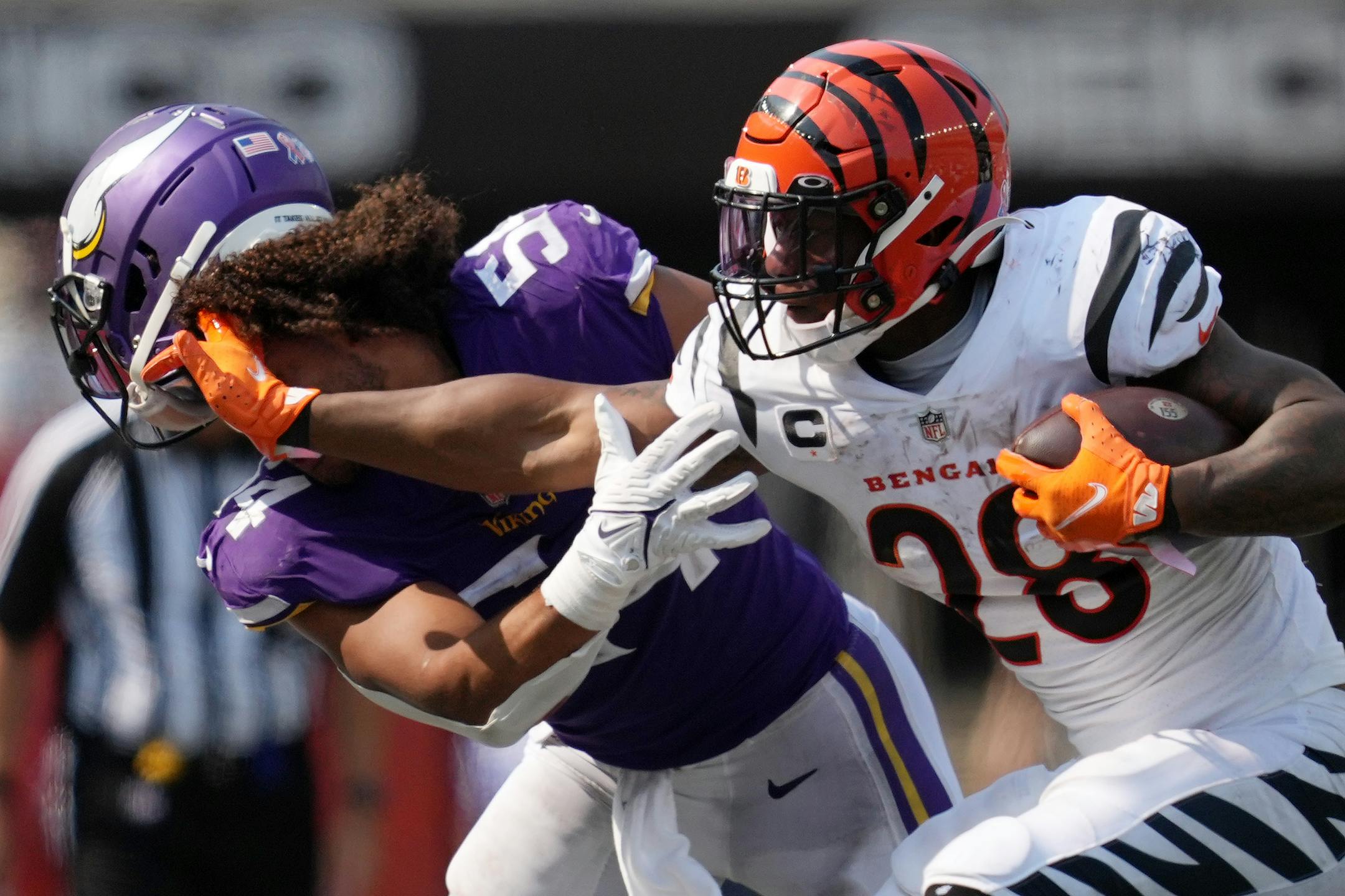 Cincinnati Bengals running back Joe Mixon (28) knocked the helmet off Minnesota Vikings middle linebacker Eric Kendricks (54) as he rushed the ball in the fourth quarter.
