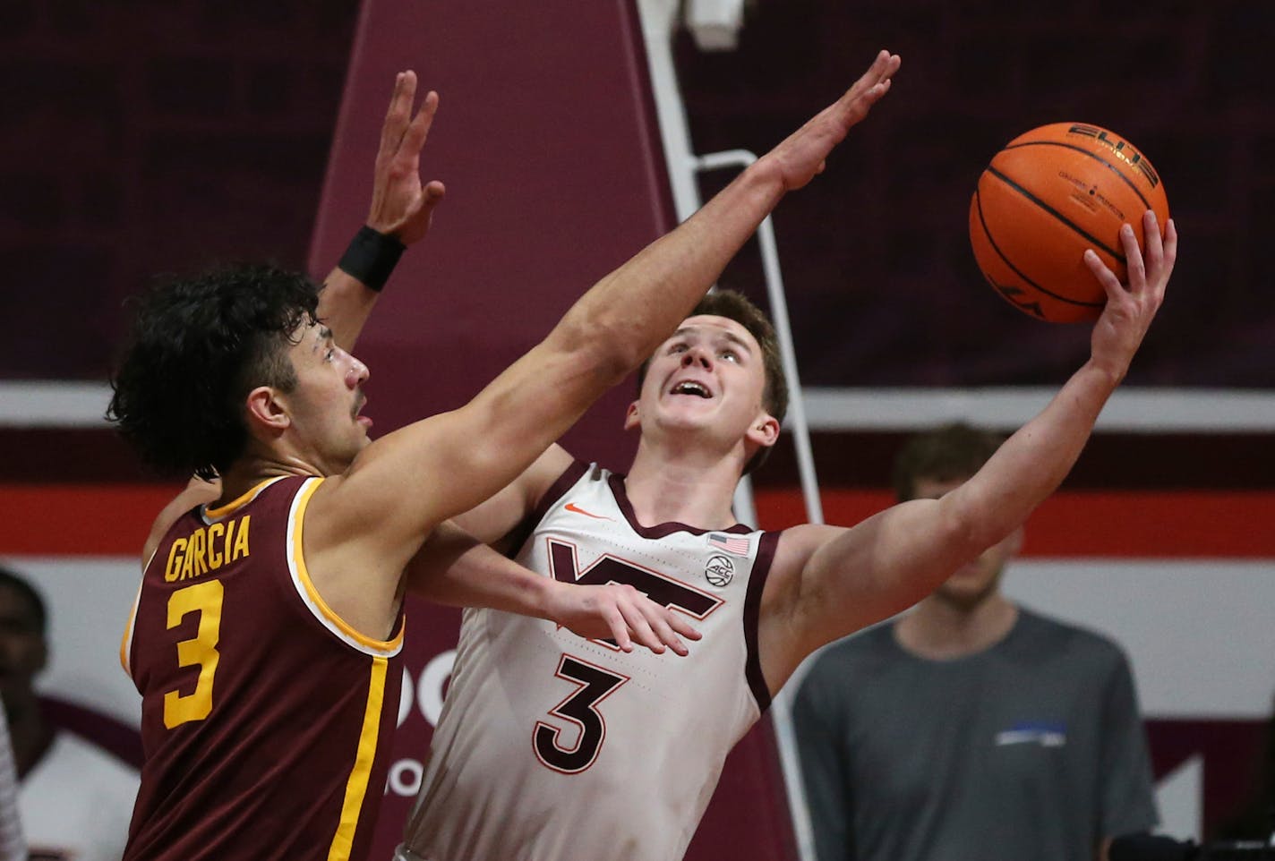 Virginia Tech's Sean Pedulla (3) scores from underneath the basket while guarded by Minnesota's Dawson Garcia (3) in the first half of an NCAA college basketball game in Blacksburg, Va., Monday, Nov. 28, 2022. (Matt Gentry/The Roanoke Times via AP)