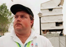 FILE- In this July 28, 1996, file photo, security guard Richard Jewell poses across from the tower where he found a bomb and warned visitors at Centen