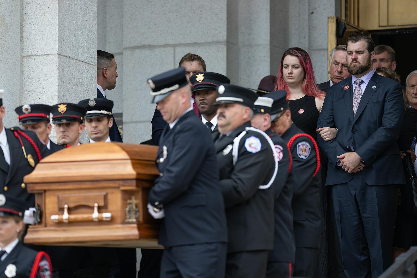 Sophie and Colin Hortman stand behind the caskets of his parents Mark and Melissa Hortman as they are lowered down the stairs after the service at the Basilica of St. Mary in Minneapolis.