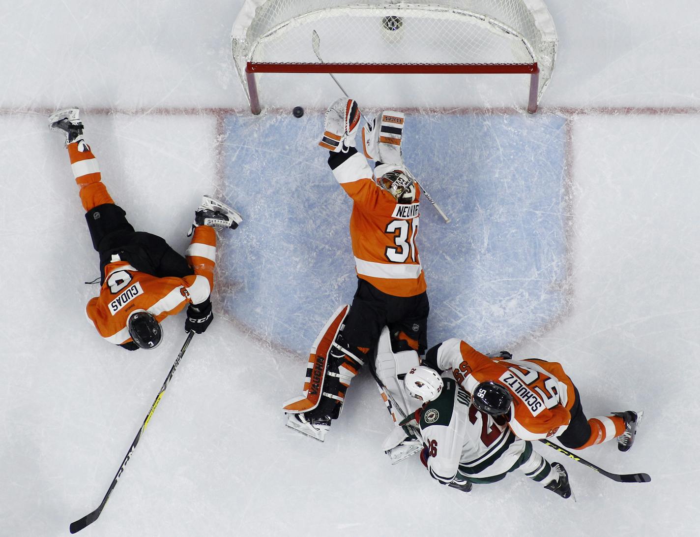 Philadelphia Flyers' Michal Neuvirth (30) blocks a shot by Minnesota Wild's Charlie Coyle past Radko Gudas (3), Nick Schultz (55) and Thomas Vanek (26) during the final seconds of an NHL hockey game, Thursday, Feb. 25, 2016, in Philadelphia. Philadelphia won 3-2. (AP Photo/Matt Slocum)