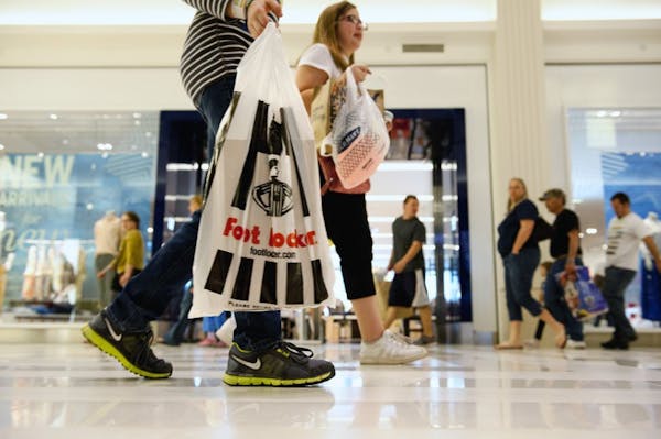 Shoppers carrying bags of clothing items pass the Gap at the Mall of America. Retail sales of apparel are showing signs of recovery. Thursday, April 5