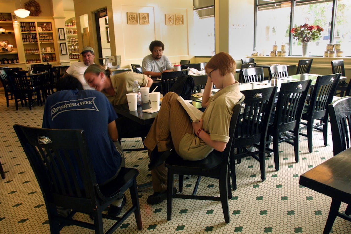 St. Paul, MN Monday 7/30/2001 The evening crew at D'Amico and Sons restaurant on Grand Avenue passed time reading, looking at vacation pictures and drinking ice water hoping that full power would be restored and they could reopen for the evening ( picture was taken around 5:00pm). Other shops and restaurants along the popular commercial stretch of Grand Av had hung 'closed' signs in the door Foreground, l-r Micheal Hamley, Julia Thompson -looking at pictures,- Betsy Burr, reading, background l-r