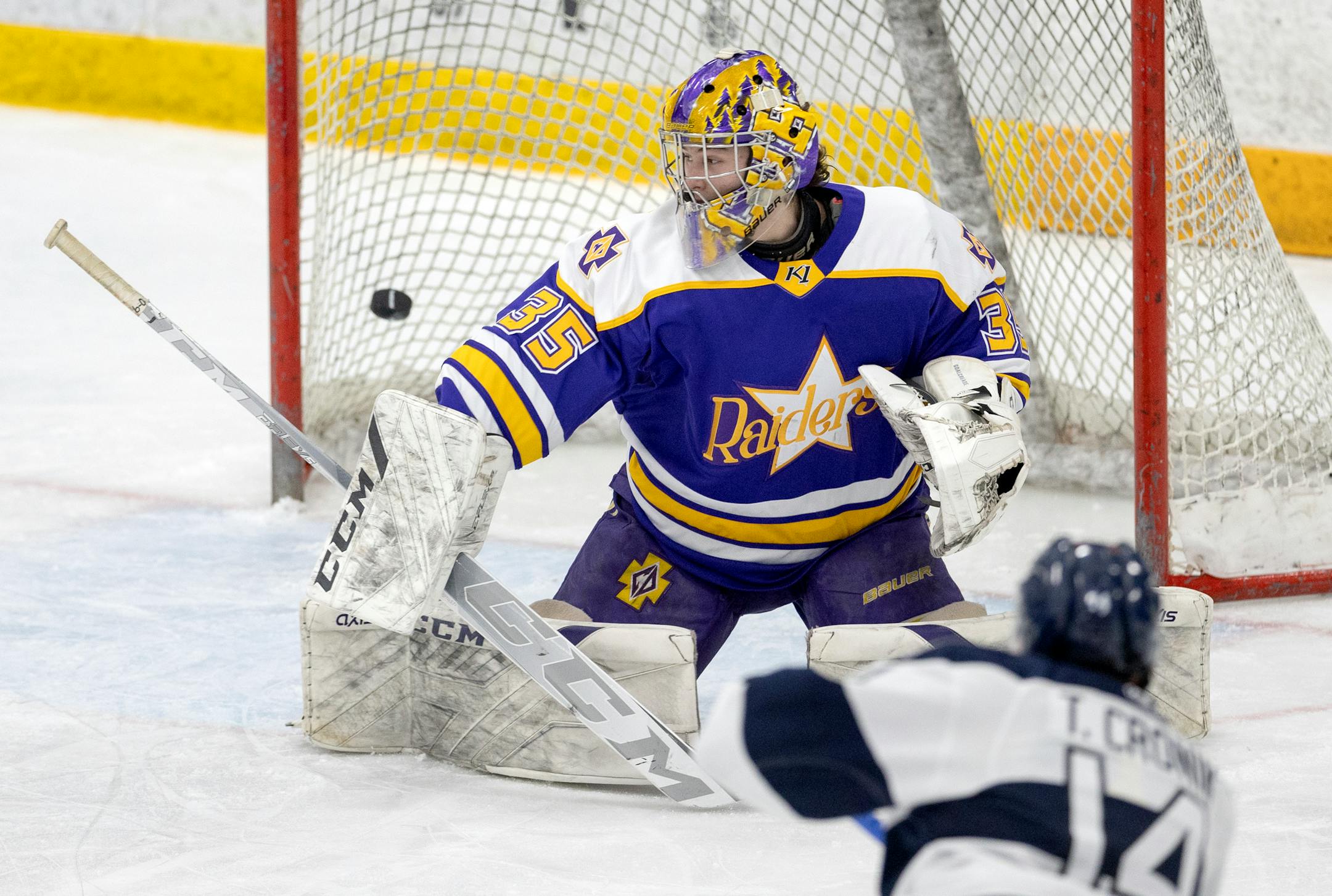 Tommy Cronin (14) of St. Thomas Academy gets the puck past Cretin-Derham Hall goalie Leo Miller (35) for a goal in the second period.