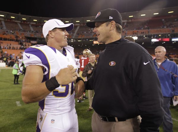 San Francisco 49ers head coach Jim Harbaugh, right, chats with the Minnesota Vikings' Toby Gerhart.