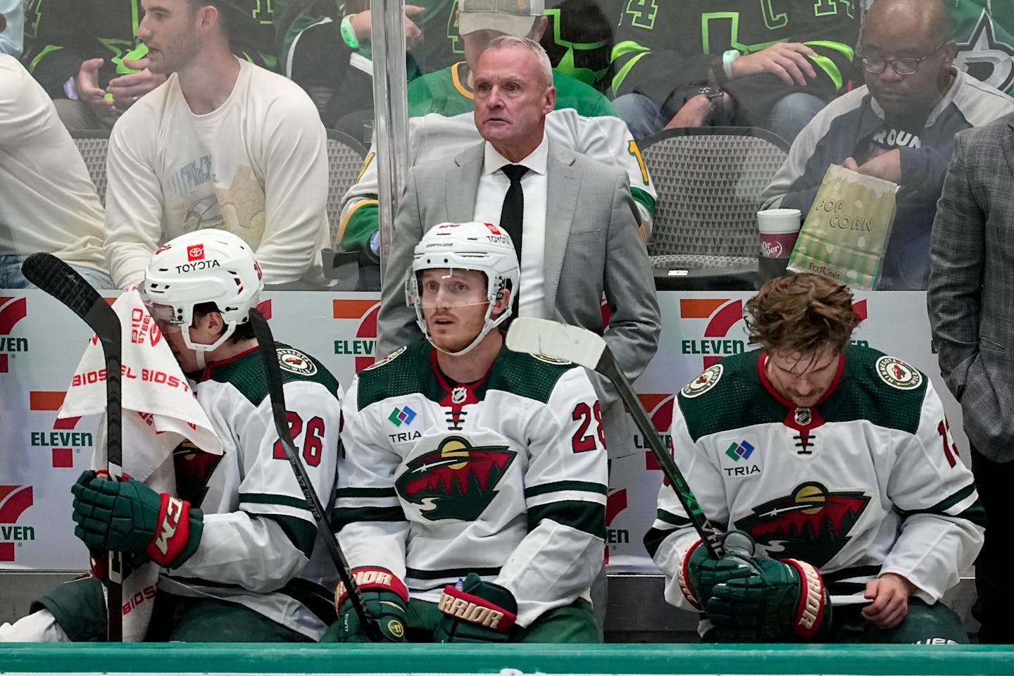 Minnesota Wild head coach Dean Evason, standing at rear, watches play against the Dallas Stars during Game 1 of an NHL hockey Stanley Cup first-round playoff series, Tuesday, April 18, 2023, in Dallas. (AP Photo/Tony Gutierrez)