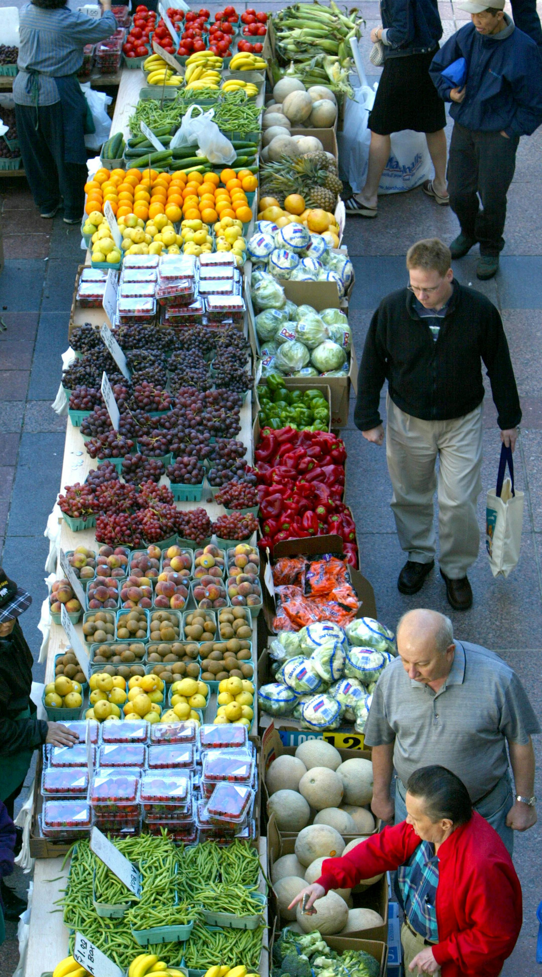 Minnneapolis, MN., Thursday, 5/16/2002. Noon shoppers at the downtown Farmers Market checked out the produce at Mai Moua's produce stand, along the Nicollet Mall near the entrance to the IDS building. ORG XMIT: MIN2015040716462561