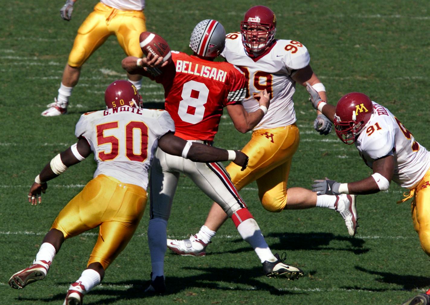 Ohio quarterback Steve Bellisari is rushed and sacked by Gophers Greg White #50, Matt Anderle #99 and Karon Riley #91 in fourth quarter action. ORG XMIT: MIN2018101219053173