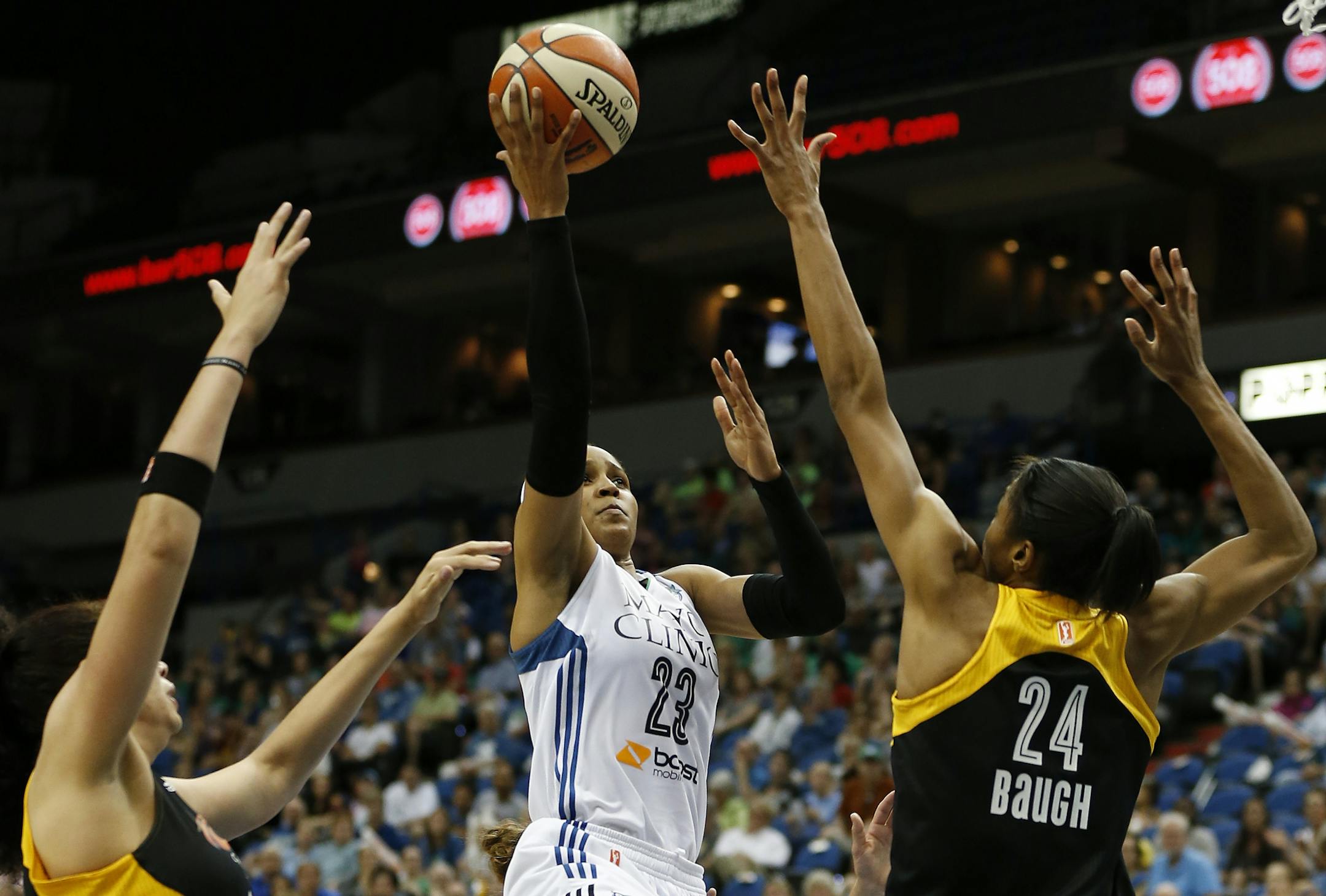 Minnesota Lynx forward Maya Moore (23) shoots the ball against the defense of Tulsa Shock's center Amanda Zahui B, left, and forward Vicki Baugh (24) during the second half of a WNBA basketball game, Sunday, June 21, 2015, in Minneapolis. Tulsa won 86-78.
