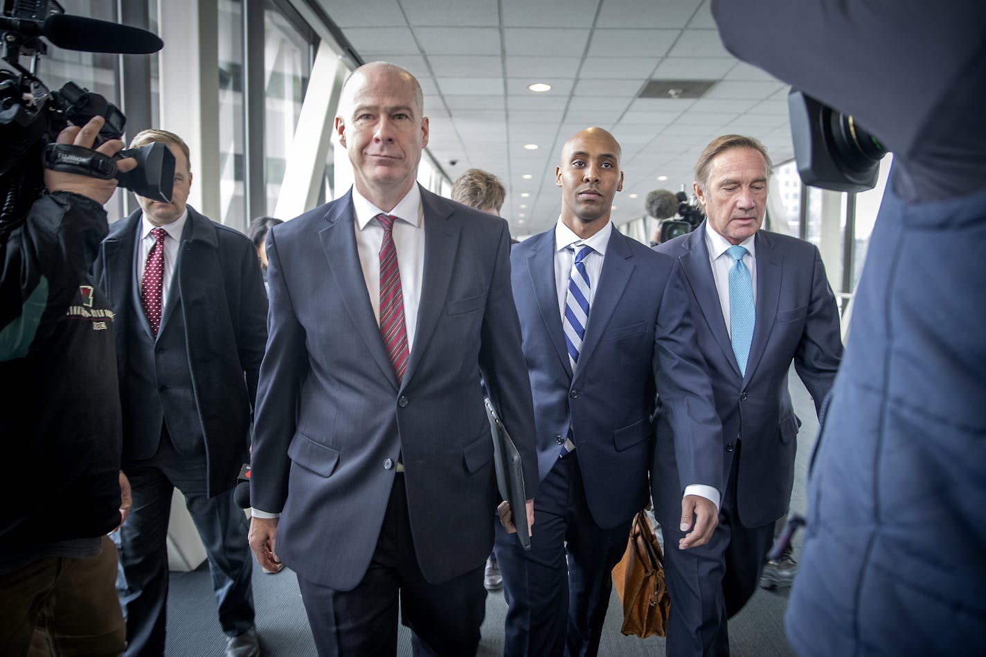 Former Minneapolis police officer Mohamed Noor, center, flanked by his attorneys, Thomas Plunkett, left, and Peter Wold, right, leaves Hennepin County Government Center after a pretrial motions hearing, Friday, March 1, 2019 in Minneapolis. Noor goes on trial April 1 in the death of Justine Ruszczyk Damond. She was shot when she approached Noor&#x2019;s squad car after making a 911 call. (Elizabeth Flores/Star Tribune via AP)