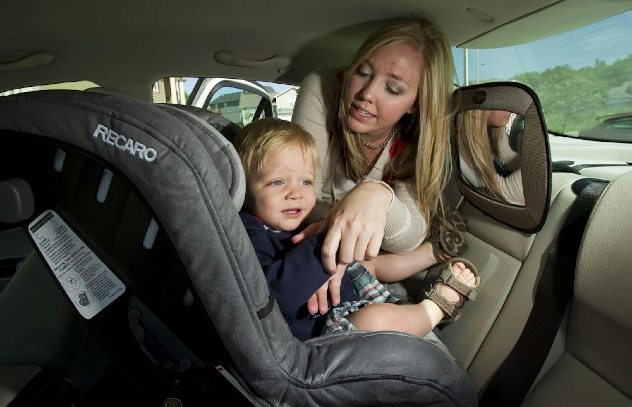 Sarah McIntosh, of Kansas City, North, buckles Ethan McIntosh, 13 months, into his car seat as they sat in their driveway, May 26, 2011, in Kansas City, Missouri. Sarah uses a stuffed doge with a "Got Ethan?" tag sitting in the front seat to remind her that Ethan is in the car with her. Since people started saving babies from airbags in the 90s by putting them in back seat car seats facing backwards, the number of babies forgotten in cars and left to die of heat strokes has skyrocketed.