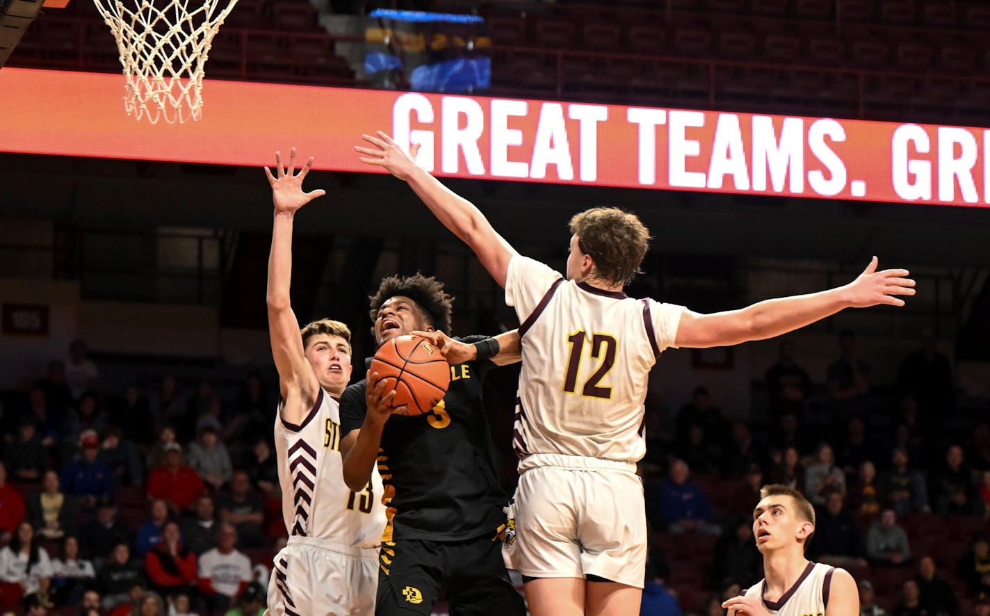 Nasir Whitlock (3) of DeLaSalle attempts a layup between Caleb Jannsen (12) of Stewartville and Jason Shindelar (13) in the second half Tuesday, March 21, 2023 during a Class 3A boys' basketball state tournament quarterfinal game at Williams Arena in Minneapolis, Minn.. ] AARON LAVINSKY • aaron.lavinsky@startribune.com