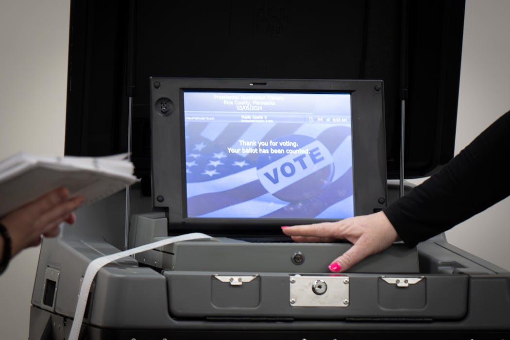 Rice County elections officials handle a voting machine during an accuracy test on Feb. 13 in Faribault, Minn.