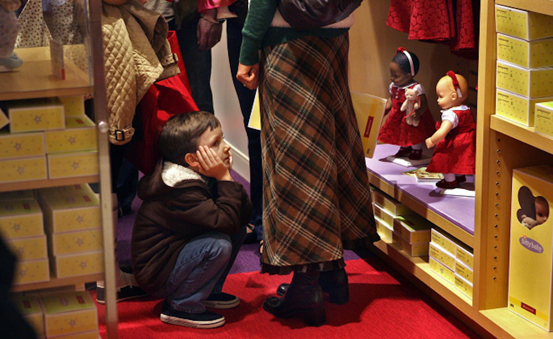 Six-year-old Quinn Avery, Rochester, patiently waited on Saturday while his two older sisters, Aerin, 14, and Veda, 13, shopped for accessories for their American Girl dolls at the new American Girl store at the Mall of America. Also with Quinn for the event were his mother, Julie, father, Amos Sr., and another brother, Amos, 10.