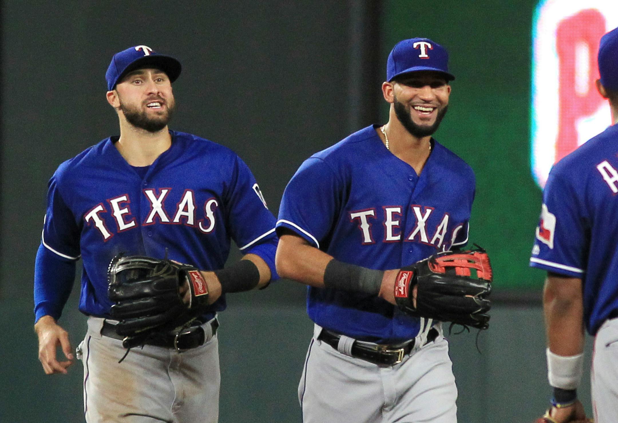 Texas Rangers outfielders Joey Gallo (13) and Nomar Mazara (30) run in after the Rangers defeated the Minnesota Twins 4-1 in a baseball game Saturday, Aug. 5, 2017, in Minneapolis. (AP Photo/Andy Clayton-King)