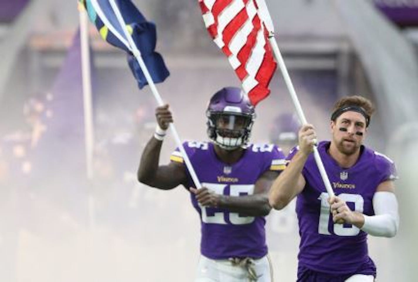 Adam Thielen (19) and Latavius Murray (25) carried flags into the stadium before the Vikings' game vs. the Lions on Nov. 4.