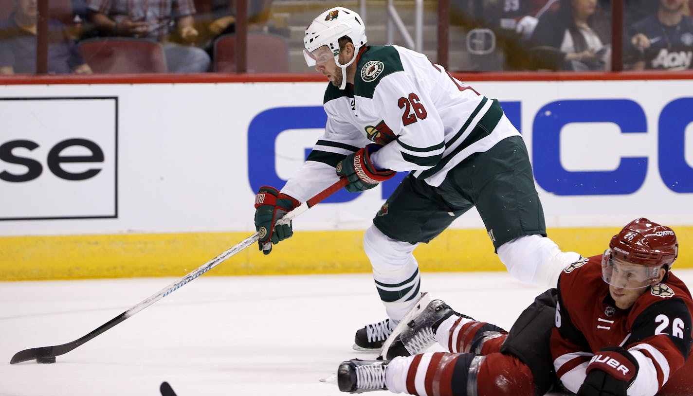 Minnesota Wild's Thomas Vanek, top, of Austria, skates around Arizona Coyotes' Michael Stone, right, prior to scoring a goal during the first period of an NHL hockey game Thursday, Oct. 15, 2015, in Glendale, Ariz. The Wild defeated the Coyotes 4-3. (AP Photo/Ross D. Franklin)