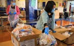 Wendy Li, left, and Rachel Huang pack meals for students to pick up on the first day of distance learning classes Sankofa United Elementary school in 