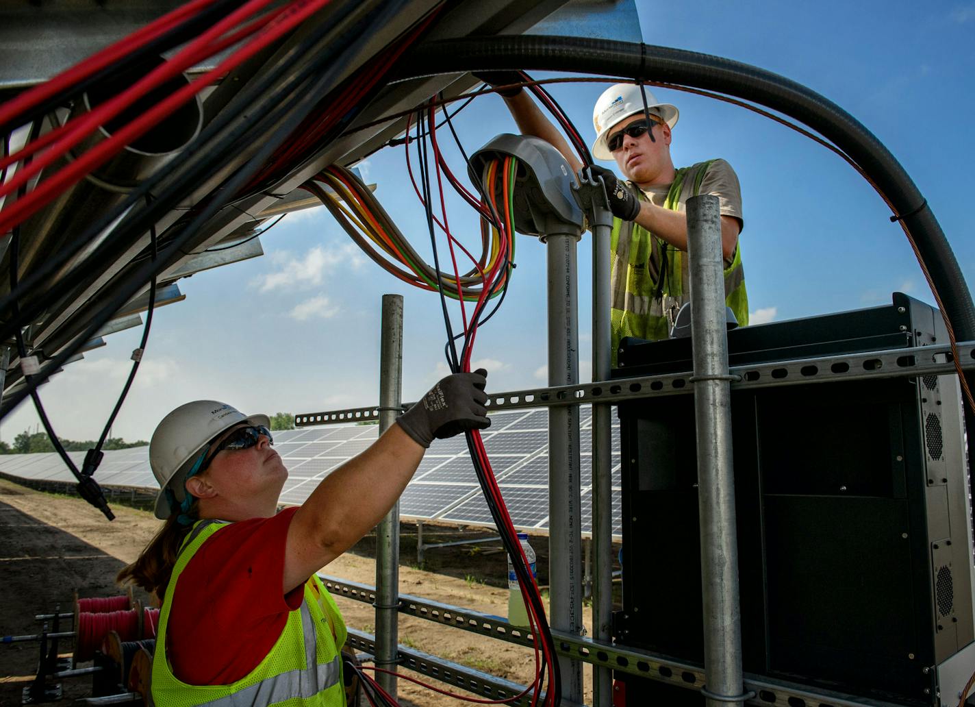 Candace May and Jason Entinger prepare wiring at a large solar project at the Blue Lake Wastewater Treatment Plant in Shakopee. ] GLEN STUBBE * gstubbe@startribune.com Thursday September 3, 2015 Workers are completing a large solar project at the Blue Lake Wastewater Treatment Plant in Shakopee that will supply electricity to it and a fertilizer operation. This is one of four solar projects in the works at the Metropolitan Council. The others are shared-solar projects called community solar gard