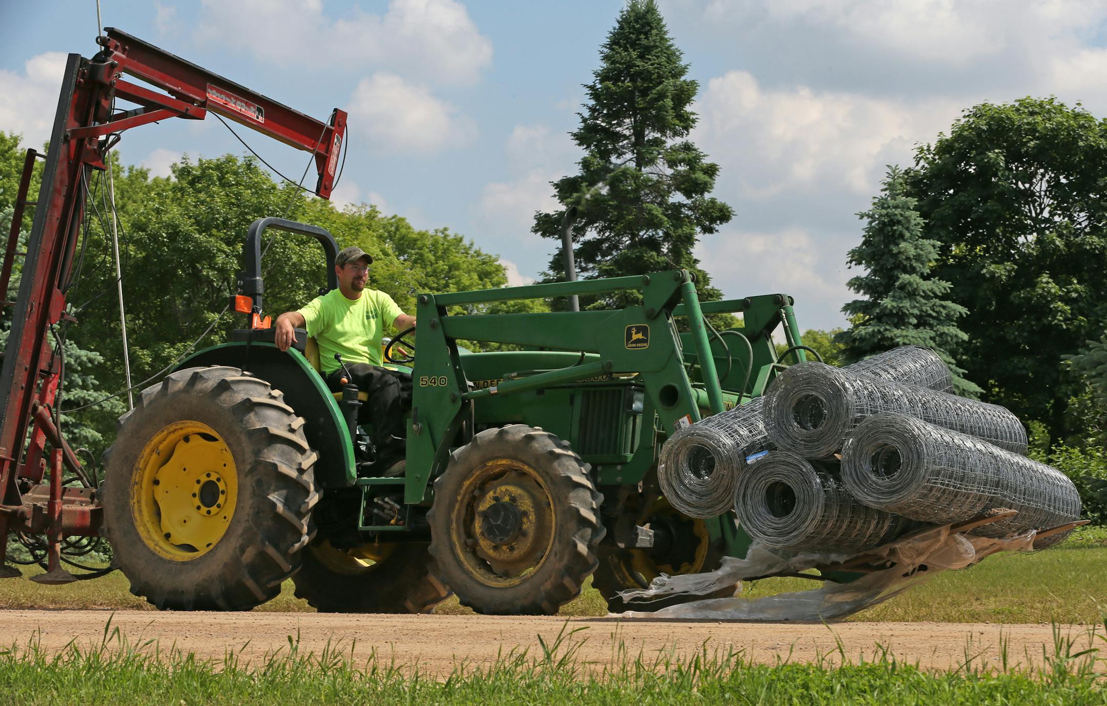 Nick Wangen of Rolling Green Fencing of Austin MN., used a tractor to move rolls of fencing to the construction site at the University of Minnesota Arboretum. Deer are munching on arbor vitae and other delicacies at the University of Minnesota Landscape Arboretum, and officials are ratcheting up their response to protect their plants and seedling trees. The latest protection effort is a new fence to keep the deer out. Neighbors don't like the fence and question whether it will be effective.] Bru