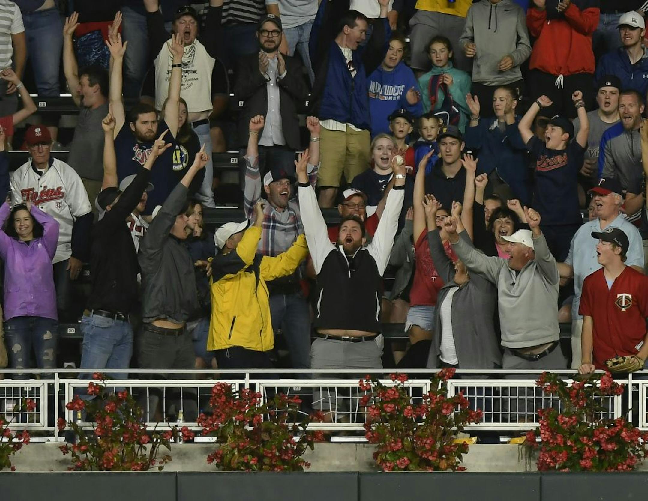 A fan celebrated after catching the home run ball hit by Minnesota Twins right fielder Max Kepler (26) in the bottom of the fifth inning against the Cleveland Indians.