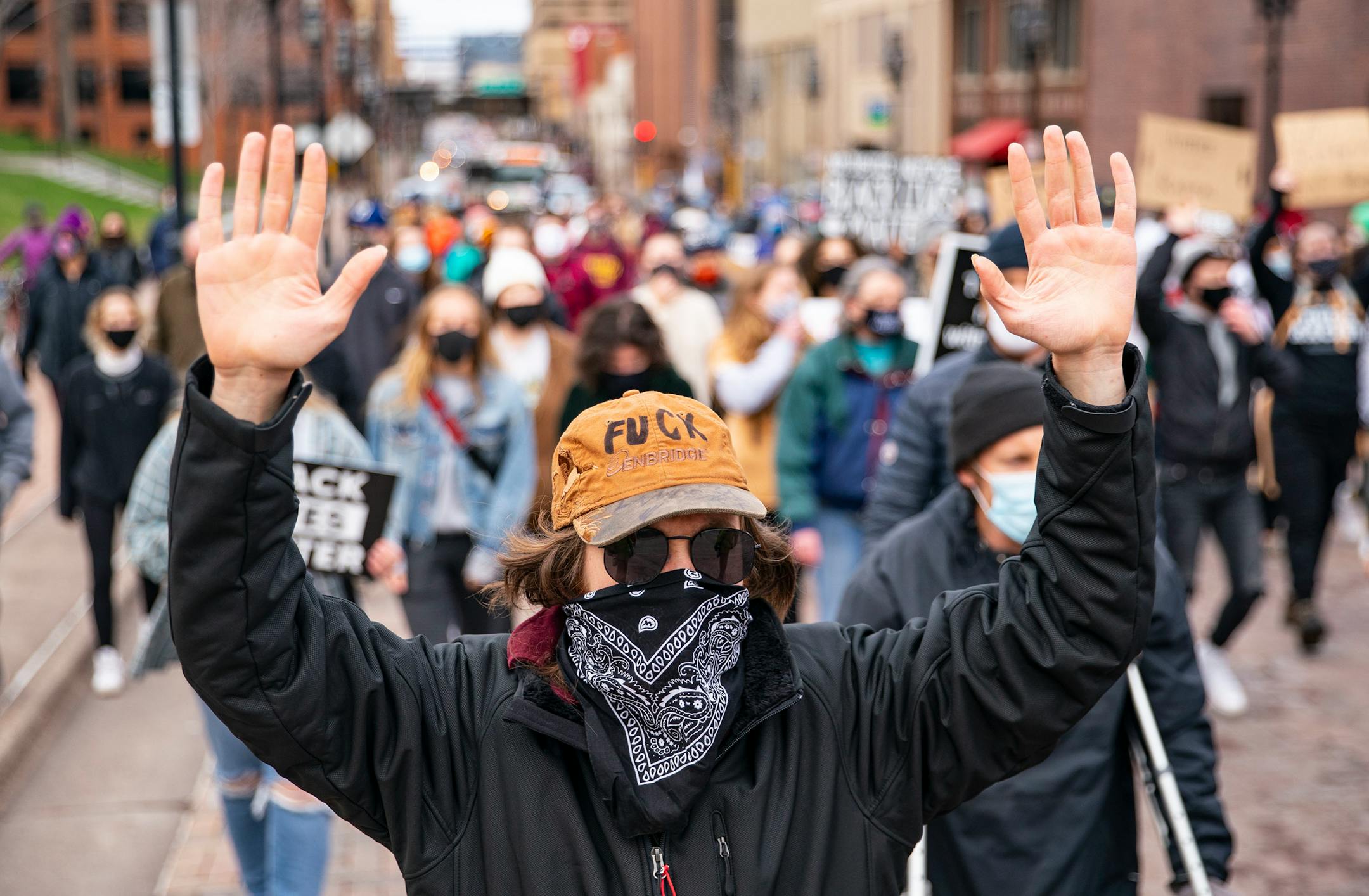 A protestor raised his hands in the air while chanting and marching towards Duluth City Hall on Wednesday.