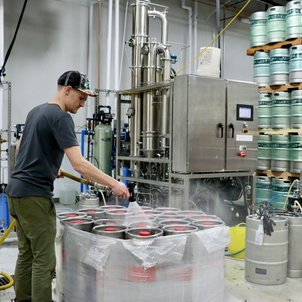 A worker inside ABV Technology preps kegs of N/A beer.