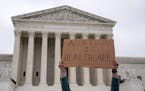 An abortion-rights demonstrator holds a sign outside the Supreme Court following a leaked draft opinion that the Supreme Court has potentially voted t
