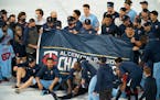 Twins players gathered on the field for a team photo with the AL Central championship banner.