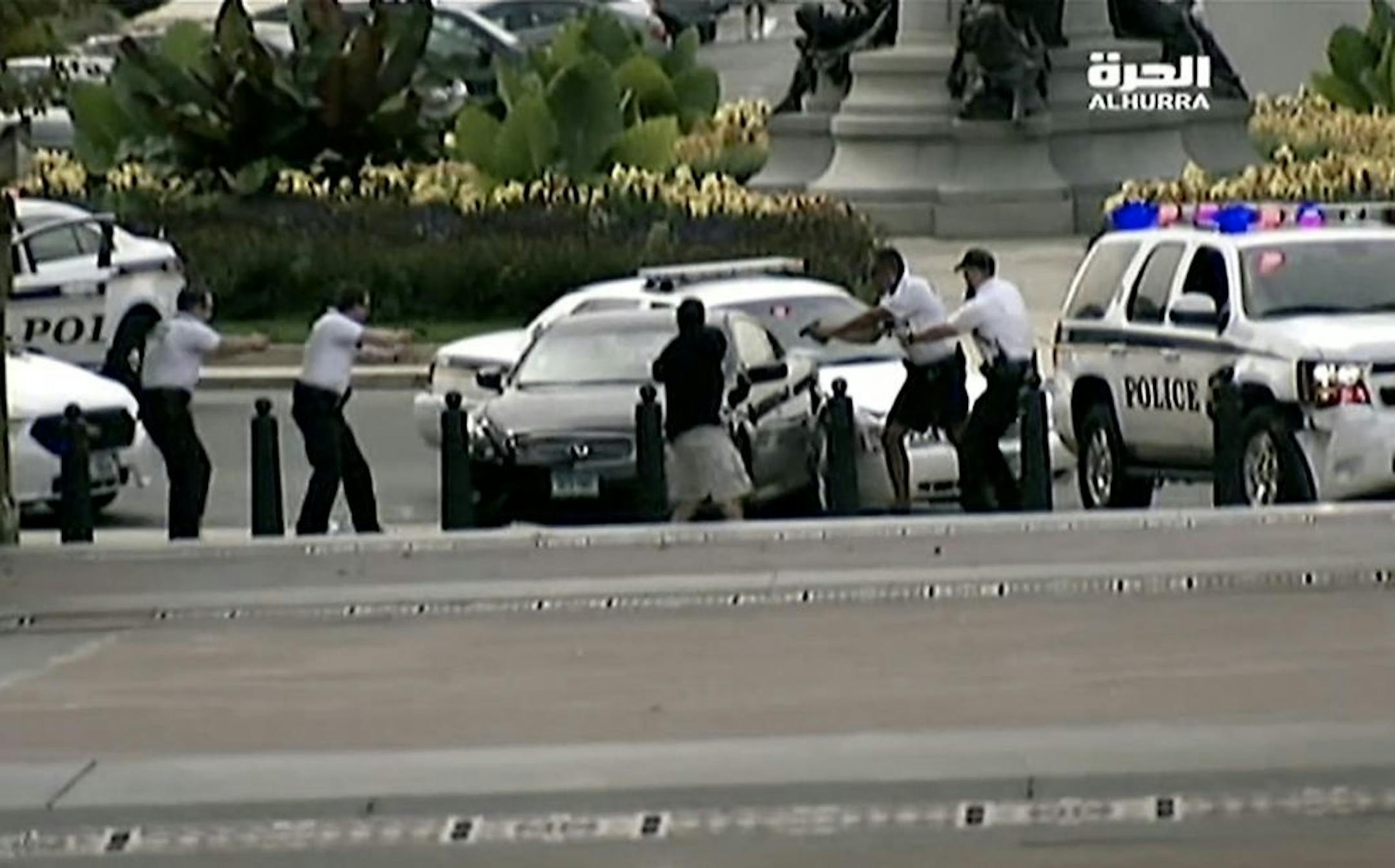 This image from video provided by Alhurra Television shows police with guns drawn surrounding a black Infiniti near the U.S. Capitol in Washington, Thursday, Oct. 3, 2013.
