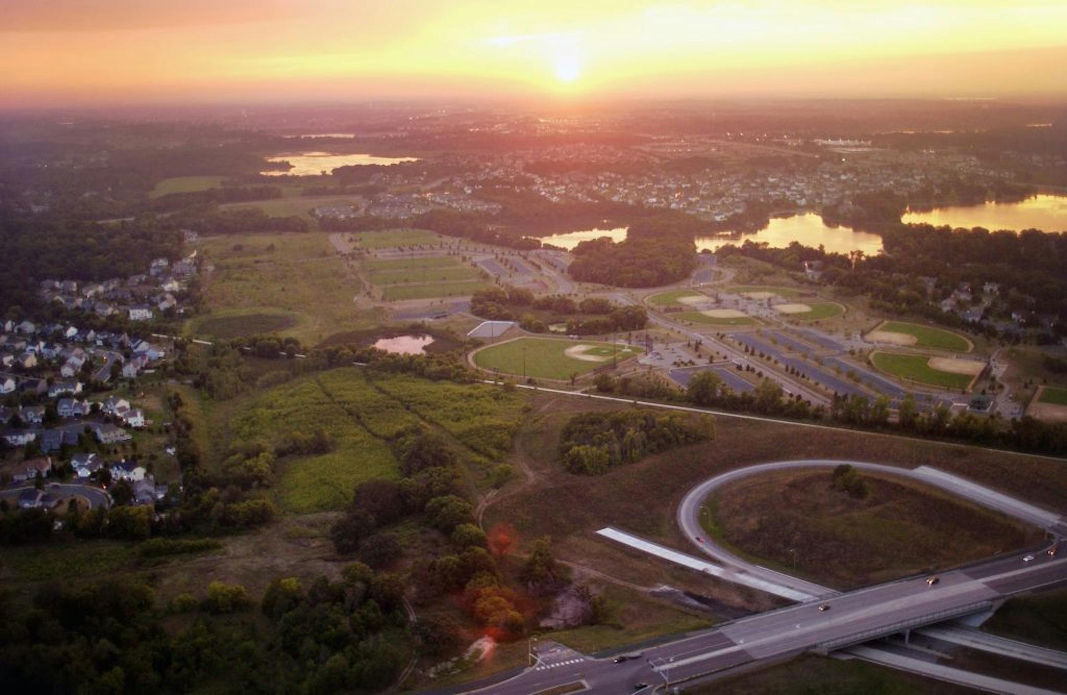 SUNDAY_08/24/03_Eden Prairie - - - - - The end of new Hwy 212 construction at bottom of frame, with land ready for construction in background, surrounded by suburban developments.