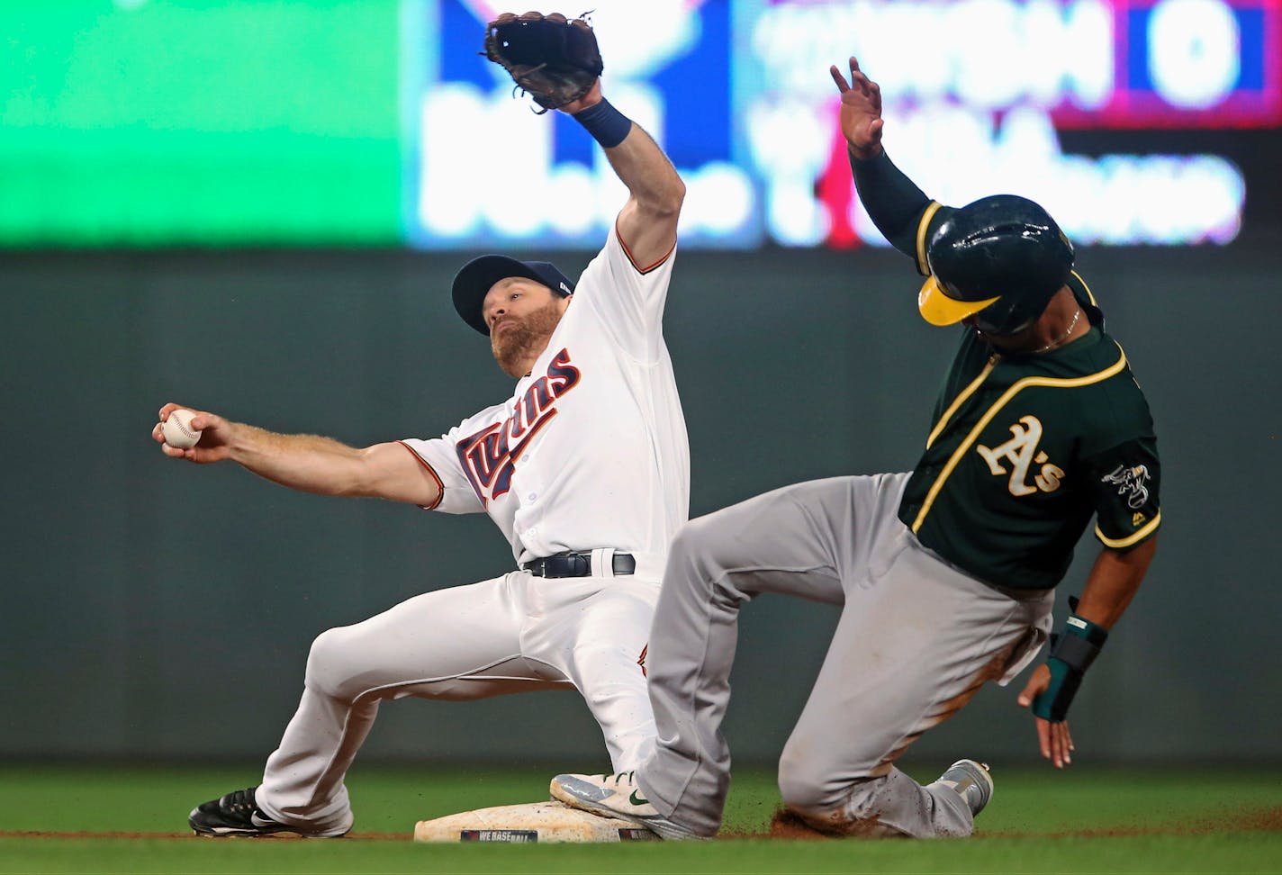 Oakland's Marcus Semien advanced to second on an infield hit as the Twins' Logan Forsythe tried to maintain his balance.