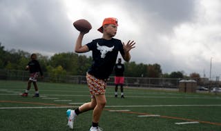 Baylor Smith, 10, was one of the young quarterbacks running drills last weekend with Cleveland McCoy.