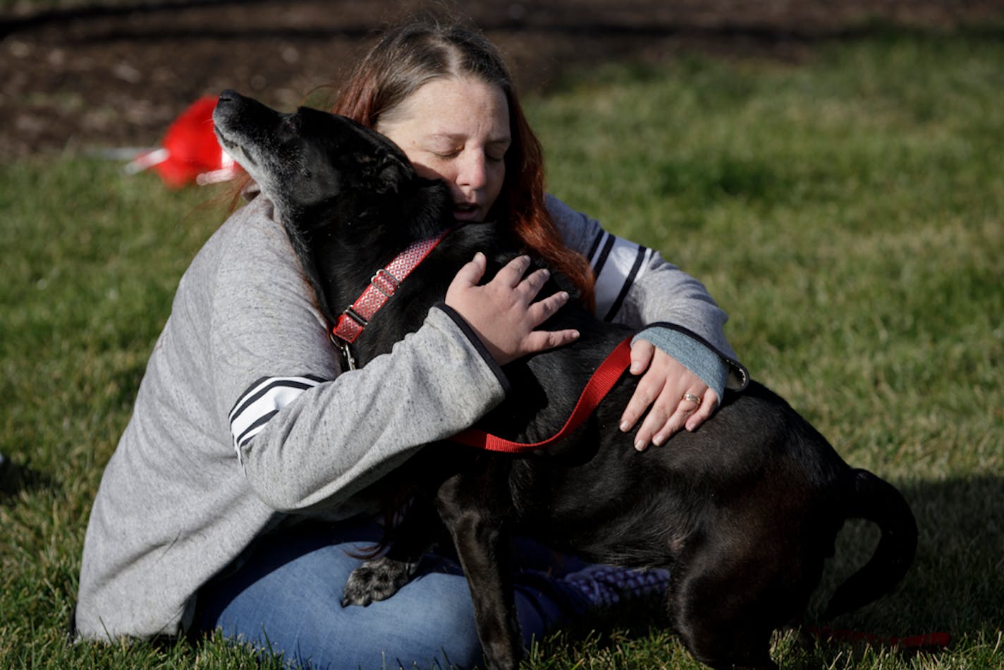 Debra Mejeur hugs her dog Lola Saturday, Dec. 5, 2020, outside DuPage County Animal Services, in Wheaton, Ill., as they reunite three years after Lola went missing during a trip to suburban Chicago. (Youngrae Kim/Chicago Tribune via AP)