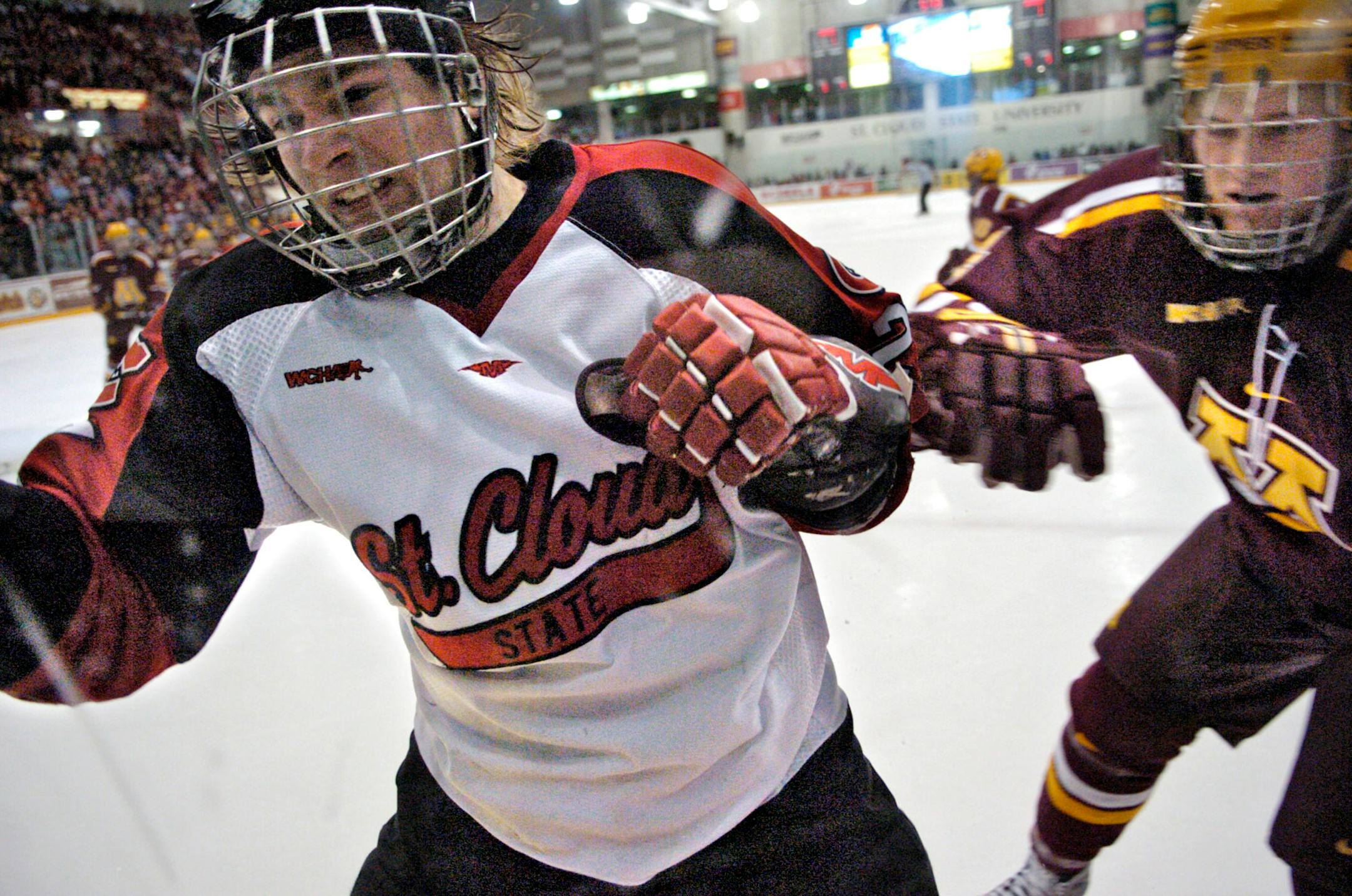 St. Cloud State's Tony Mosey, left, and Minnesota's Stu Bickel collide against the boards during the first period of a hockey game Saturday, Jan. 12, 2008, at the National Hockey Center in St. Cloud, Minn.