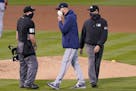 Minnesota Twins manager Rocco Baldelli, middle, talks with umpire Scott Barry (87) during the fourth inning of the second baseball game of a doublehea