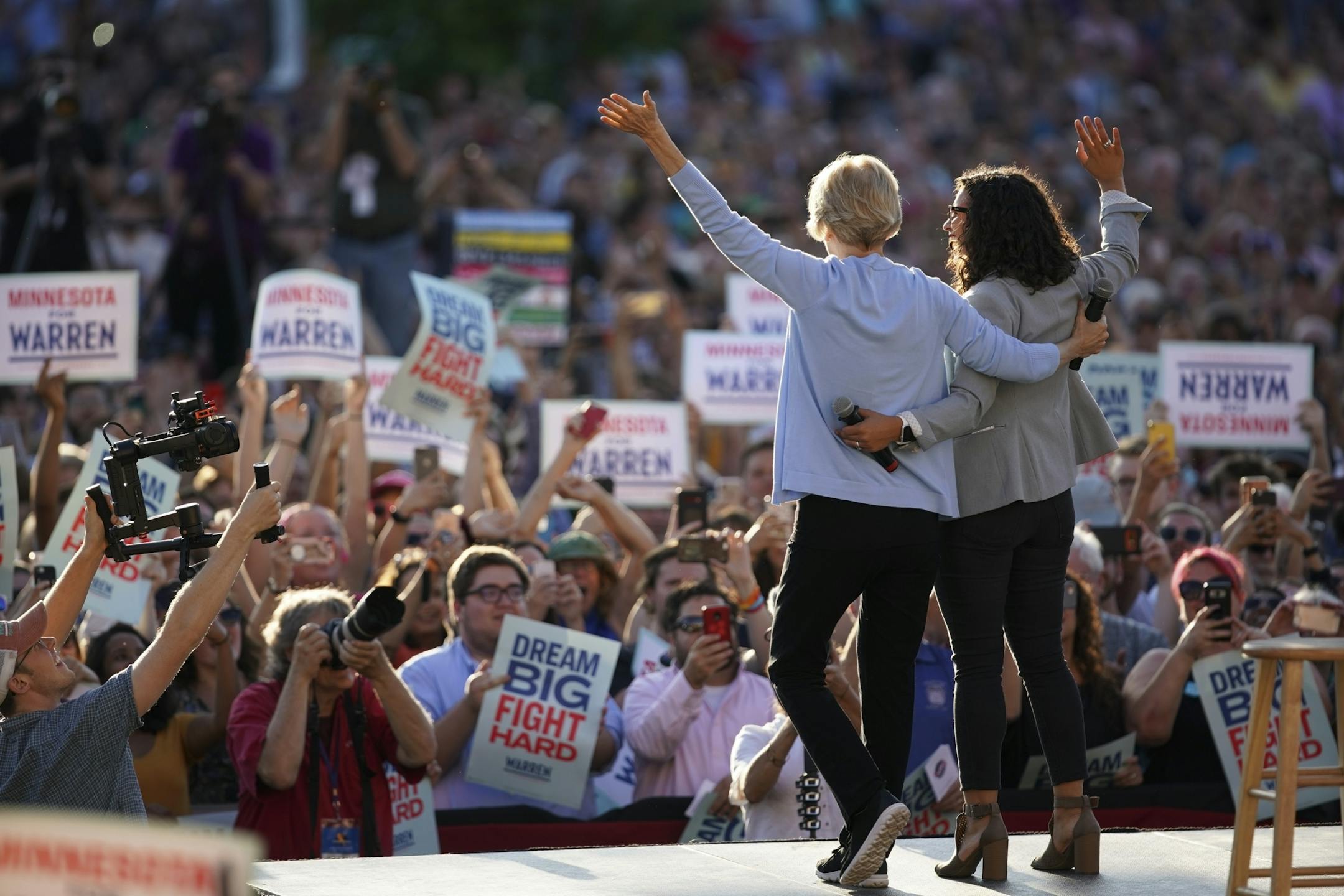 Sen. Elizabeth Warren greeted the crowd with Erin Maye Quade, who introduced her before the Town Hall on Shaw Field at Macalester College Monday evening.