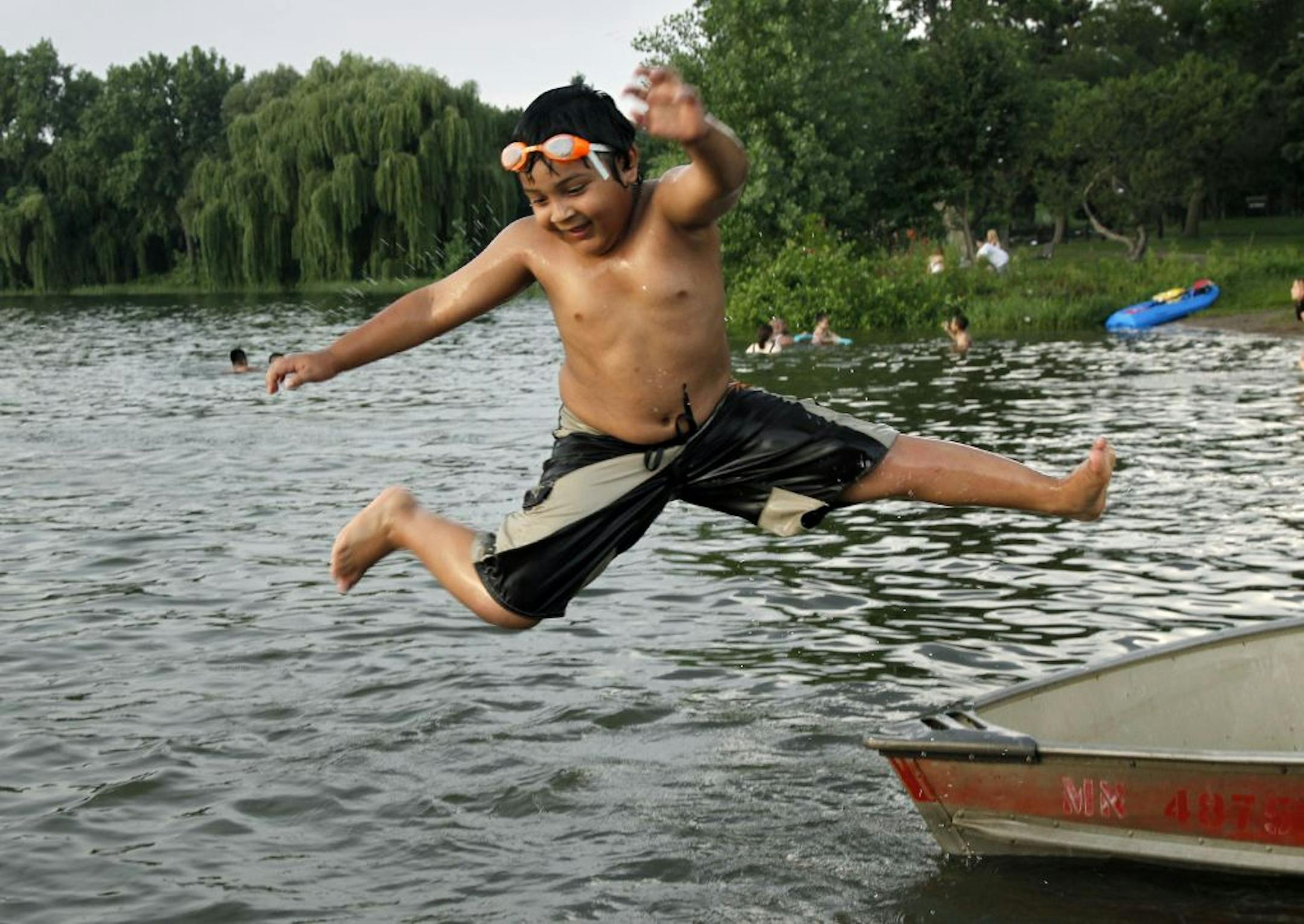 Emilio Campo, 6, takes off from a tied-off boat at the east shore Lake Nokomis swimming area last week. He was swimming with his family that had come to the lake to get a break from the high humidity and temperatures