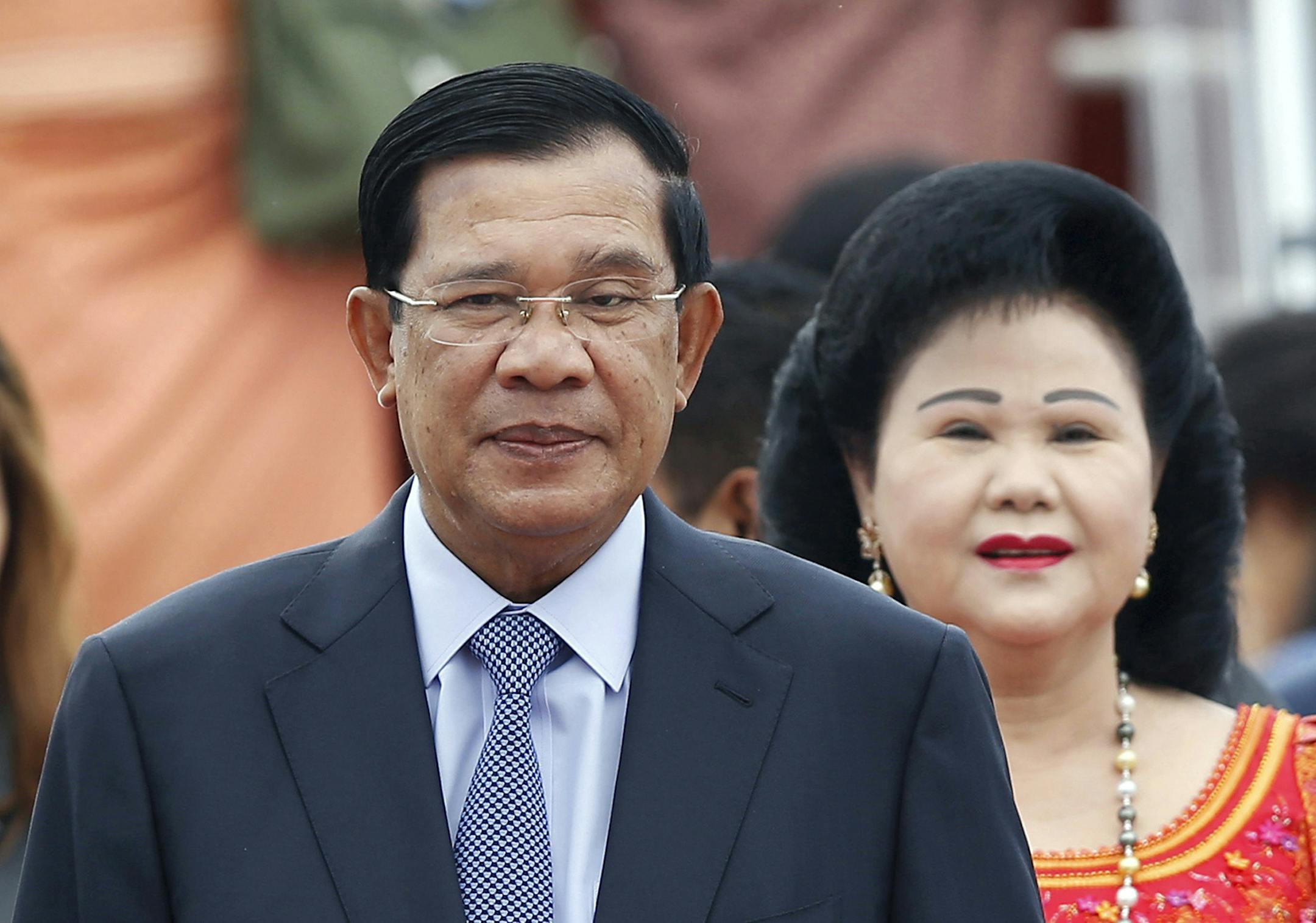 RETRANSMISSION WITH CORRECT SLUG - FILE - In this Nov. 20, 2015 file photo, Cambodia's Prime Minister Hun Sen and his wife Bun Rany arrive for the 27th Association of Southeast Asian Nations (ASEAN) summit, in Sepang, Malaysia. An extensive network of businesses controlled by the family of Cambodia's longtime leader sustains and is sustained by his authoritarian rule, making foreign investment in the country risky, says a report issued Thursday, July 7, 2016 by the research and advocacy group Gl