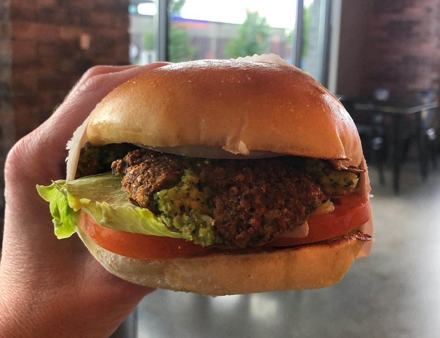 A hand holding a burger.