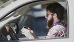 FILE - In this Feb. 26, 2013 file photo, a man uses his cell phone as he drives through traffic in Dallas. In a new survey, 98 percent of motorists wh