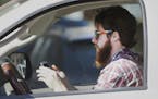 FILE - In this Feb. 26, 2013 file photo, a man uses his cell phone as he drives through traffic in Dallas. In a new survey, 98 percent of motorists wh