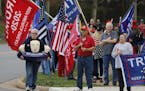 Supporters of President Donald Trump gather outside Trump National Golf Club in Sterling, Va., while the president plays golf, on Saturday, Nov. 21, 2