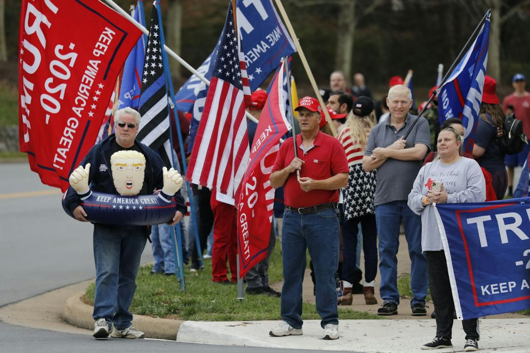 Supporters of President Donald Trump gather outside Trump National Golf Club in Sterling, Va., while the president plays golf, on Saturday, Nov. 21, 2020.