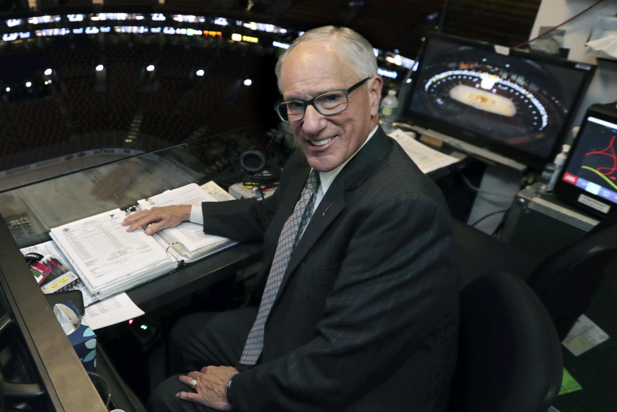 FILE - In this Wednesday, May 29, 2019, file photo, NBC hockey broadcaster Mike Emrick poses for a photo while preparing to call Game 2 of the NHL hockey Stanley Cup Final between the St. Louis Blues and the Boston Bruins, in Boston. Hall of Fame hockey broadcaster Mike Emrick is retiring after a career of almost 50 years behind the microphone, including the past 15 as the voice of the NHL in the United States. (AP Photo/Charles Krupa, File)