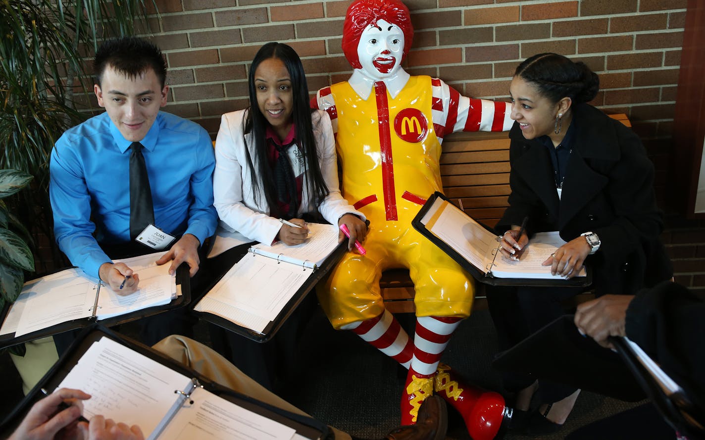 McDonald's restaurant general managers, from left, Juan Castaneda, Carmen Caba and Joanna Molina meet as a team to consolidate their notes and discuss as they gather around a Ronald McDonald statue at McDonald's University on April 14, 2015 in Oak Brook, Ill. (Antonio Perez/Chicago Tribune/TNS) ORG XMIT: 1167109