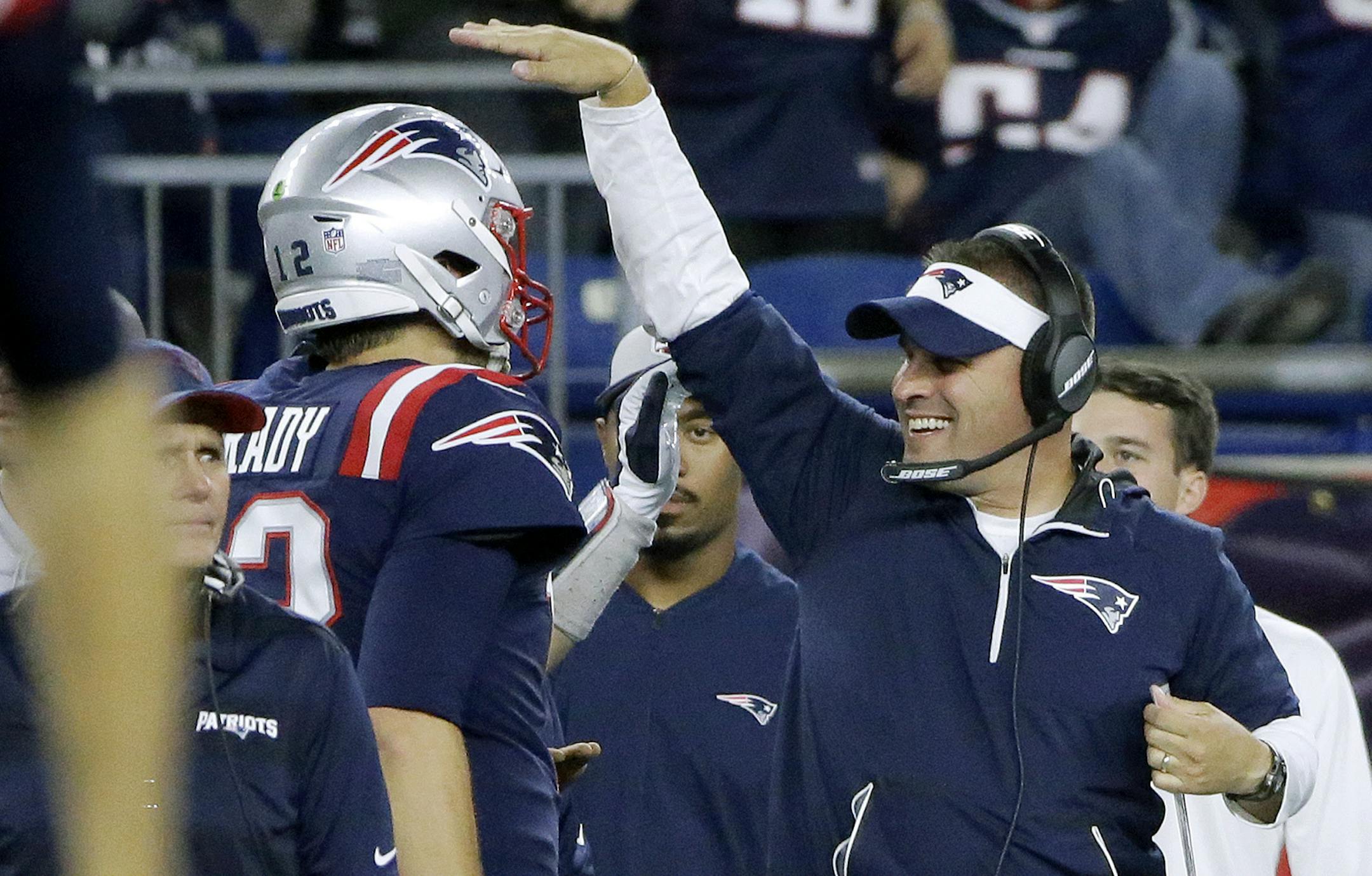 New England Patriots offensive coordinator Josh McDaniels, right, gives quarterback Tom Brady a tap after a touchdown run by Sony Michel during the second half of an NFL football game against the Indianapolis Colts, Thursday, Oct. 4, 2018, in Foxborough, Mass. (AP Photo/Steven Senne)