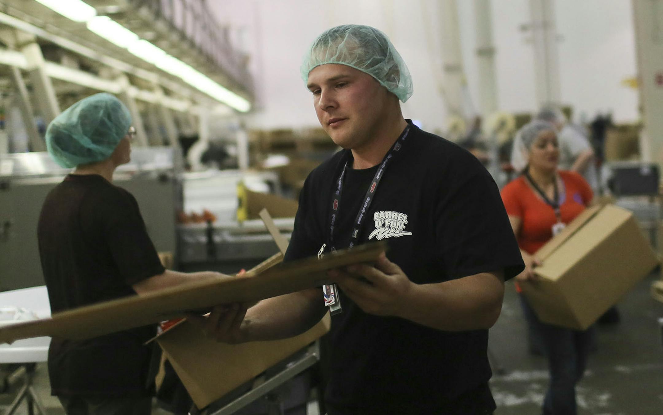 A group of mostly Ukrainian workers have come to Perham this summer for employment at KLN Enterprises, the family-owned parent company of Barrel O' Fun that also manufactures snack brands for other companies. Here, Ukrainian Vitalii Kovbasiuk folds a box while on a potato chip line at at KLN Enterprises Wednesday, July 16, 2014, in Perham, MN.] (DAVID JOLES/STARTRIBUNE) djoles@startribune More than 60 international workers, mostly from Ukraine, are flew to Minnesota recently to take jobs in litt